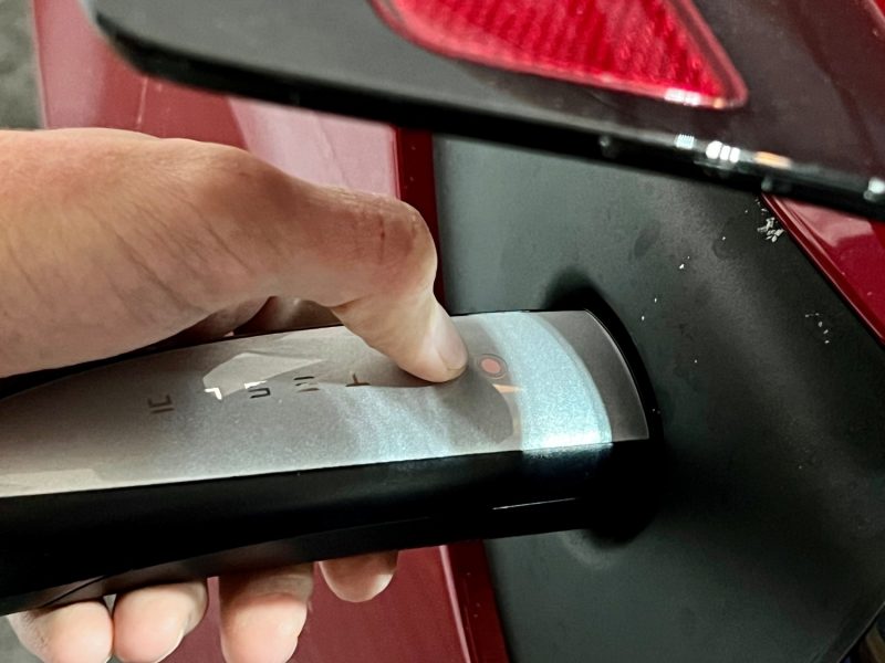 Button on the handle unlocks the charge port