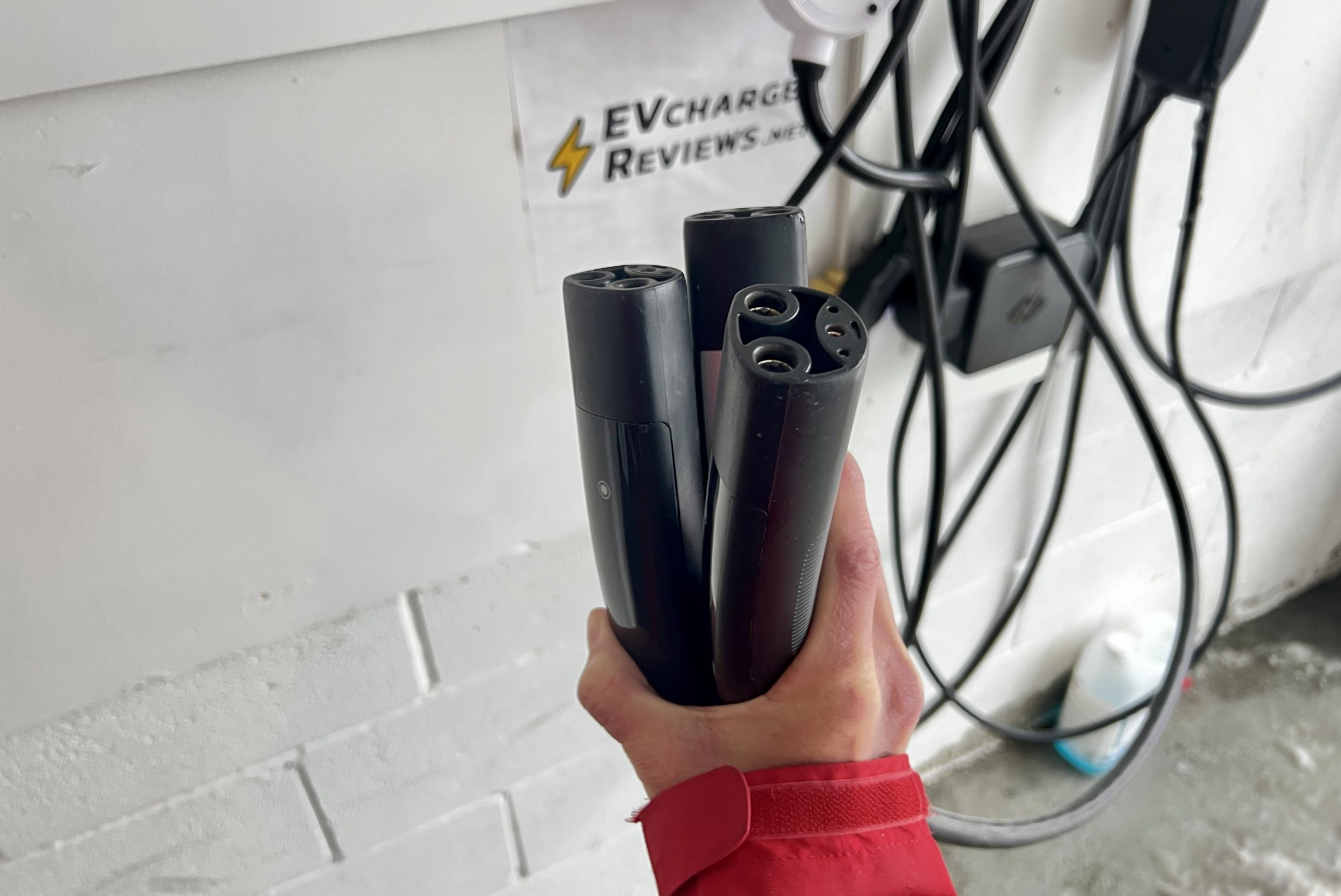 Three different NACS connectors shown during testing in my garage. We looked at NACS EV chargers from all the major brands. 